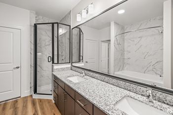 A bathroom with a marble countertop and a walk-in shower. at Aurora Watson Branch, Mansfield